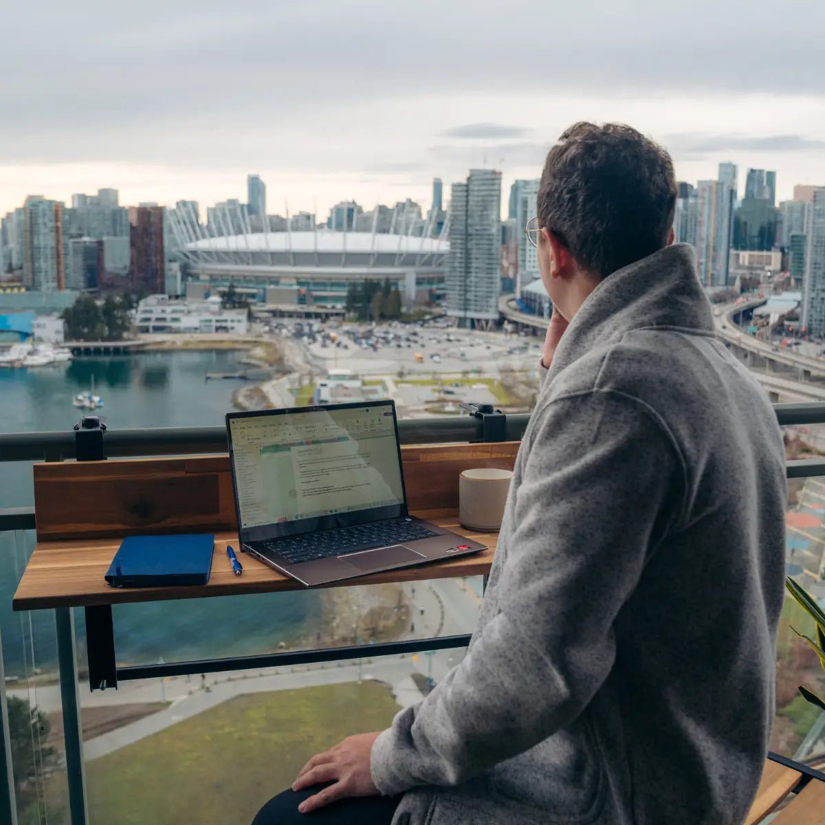 Views Balcony Bar (3Ft) man working from laptop on outdoor bar top with a city view